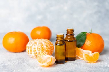 Tahta bir masada mandalina yağı. Bir şişe turunçgil yağı ve dilimlenmiş meyve. Mandalina kokulu mandalina yağı. Spa tedavileri için kozmetik yağı. Aromaterapi kavramı.