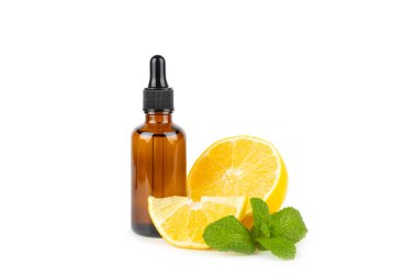 Limon dilimlenmiş limonlu bir şişede limon yağı ve beyaz arka planda izole edilmiş yapraklar. Limon yağı. Aromatik esanslı parfüm şişesi. Serum, limon özü. C vitamini. Doğal kozmetik ürünler. Aromaterapi. Spa mı? Metin için boşluk.