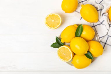 Tahta bir masada limon. Bir dilim taze limon. Turunçgil yapraklı taze limon. Limon suyu. Yemek ve içecek malzemeleri hazırlanıyor. Sağlıklı beslenme. Metin için C vitamini alanı.