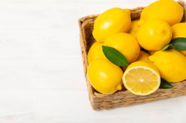 Tahta bir masada limon. Bir dilim taze limon. Turunçgil yapraklı taze limon. Limon suyu. Yemek ve içecek malzemeleri hazırlanıyor. Sağlıklı beslenme. Metin için C vitamini alanı.