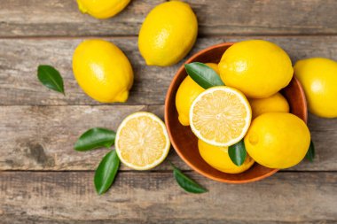 Tahta bir masada limon. Bir dilim taze limon. Turunçgil yapraklı taze limon. Limon suyu. Yemek ve içecek malzemeleri hazırlanıyor. Sağlıklı beslenme. Metin için C vitamini alanı.