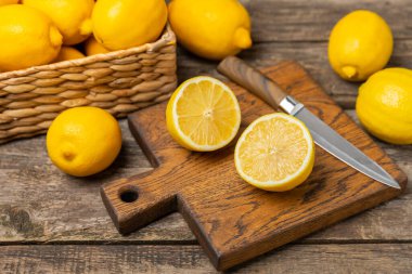 Tahta bir masada limon. Bir dilim taze limon. Turunçgil yapraklı taze limon. Limon suyu. Yemek ve içecek malzemeleri hazırlanıyor. Sağlıklı beslenme. Metin için C vitamini alanı.