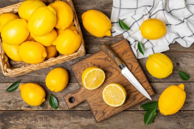 Tahta bir masada limon. Bir dilim taze limon. Turunçgil yapraklı taze limon. Limon suyu. Yemek ve içecek malzemeleri hazırlanıyor. Sağlıklı beslenme. Metin için C vitamini alanı.