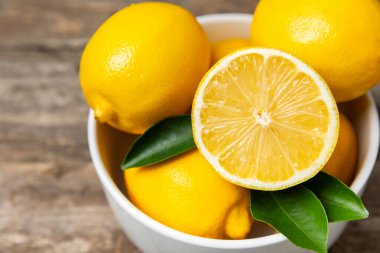 Tahta bir masada limon. Bir dilim taze limon. Turunçgil yapraklı taze limon. Limon suyu. Yemek ve içecek malzemeleri hazırlanıyor. Sağlıklı beslenme. Metin için C vitamini alanı.