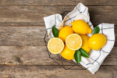 Tahta bir masada limon. Bir dilim taze limon. Turunçgil yapraklı taze limon. Limon suyu. Yemek ve içecek malzemeleri hazırlanıyor. Sağlıklı beslenme. Metin için C vitamini alanı.