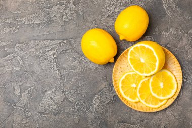 Tahta bir masada limon. Bir dilim taze limon. Turunçgil yapraklı taze limon. Limon suyu. Yemek ve içecek malzemeleri hazırlanıyor. Sağlıklı beslenme. Metin için C vitamini alanı.