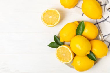 Tahta bir masada limon. Bir dilim taze limon. Turunçgil yapraklı taze limon. Limon suyu. Yemek ve içecek malzemeleri hazırlanıyor. Sağlıklı beslenme. Metin için C vitamini alanı.