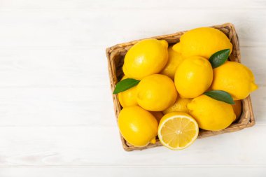 Tahta bir masada limon. Bir dilim taze limon. Turunçgil yapraklı taze limon. Limon suyu. Yemek ve içecek malzemeleri hazırlanıyor. Sağlıklı beslenme. Metin için C vitamini alanı.