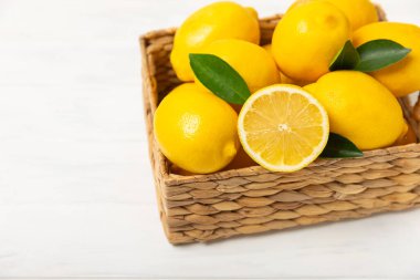 Tahta bir masada limon. Bir dilim taze limon. Turunçgil yapraklı taze limon. Limon suyu. Yemek ve içecek malzemeleri hazırlanıyor. Sağlıklı beslenme. Metin için C vitamini alanı.