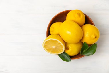 Tahta bir masada limon. Bir dilim taze limon. Turunçgil yapraklı taze limon. Limon suyu. Yemek ve içecek malzemeleri hazırlanıyor. Sağlıklı beslenme. Metin için C vitamini alanı.