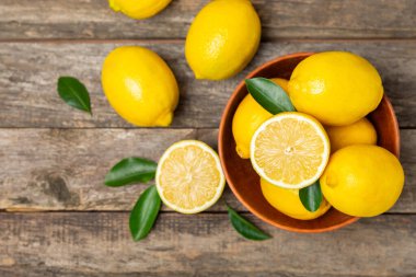 Tahta bir masada limon. Bir dilim taze limon. Turunçgil yapraklı taze limon. Limon suyu. Yemek ve içecek malzemeleri hazırlanıyor. Sağlıklı beslenme. Metin için C vitamini alanı.