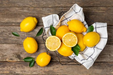 Tahta bir masada limon. Bir dilim taze limon. Turunçgil yapraklı taze limon. Limon suyu. Yemek ve içecek malzemeleri hazırlanıyor. Sağlıklı beslenme. Metin için C vitamini alanı.