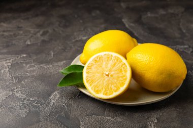 Tahta bir masada limon. Bir dilim taze limon. Turunçgil yapraklı taze limon. Limon suyu. Yemek ve içecek malzemeleri hazırlanıyor. Sağlıklı beslenme. Metin için C vitamini alanı.