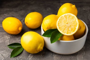Tahta bir masada limon. Bir dilim taze limon. Turunçgil yapraklı taze limon. Limon suyu. Yemek ve içecek malzemeleri hazırlanıyor. Sağlıklı beslenme. Metin için C vitamini alanı.