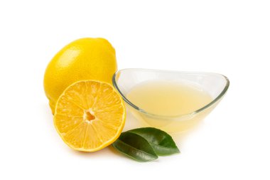 Limon suyu. Beyaz arka planda izole edilmiş bir kasede taze limon suyu. Olgun narenciye, nane, meyve suyu ve masada meyve sıkacağı. C vitamini. Limon suyu. Pişirme veya salata sosu için gerekli malzemeler.