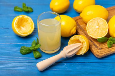 Limon suyu. Kasede taze limon suyu. Olgun narenciye, nane, meyve suyu ve masada meyve sıkacağı. C vitamini. Limon suyu. Pişirme ya da salata sosu için. Mesaj için yer var. Boşluğu kopyala.