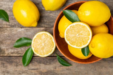 Tahta bir masada limon. Bir dilim taze limon. Turunçgil yapraklı taze limon. Limon suyu. Yemek ve içecek malzemeleri hazırlanıyor. Sağlıklı beslenme. Metin için C vitamini alanı.