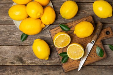 Tahta bir masada limon. Bir dilim taze limon. Turunçgil yapraklı taze limon. Limon suyu. Yemek ve içecek malzemeleri hazırlanıyor. Sağlıklı beslenme. Metin için C vitamini alanı.