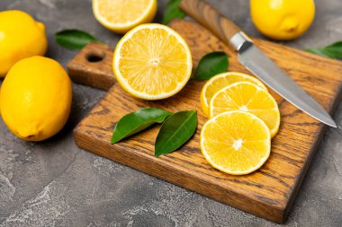 Tahta bir masada limon. Bir dilim taze limon. Turunçgil yapraklı taze limon. Limon suyu. Yemek ve içecek malzemeleri hazırlanıyor. Sağlıklı beslenme. Metin için C vitamini alanı.