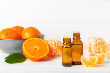 Tahta bir masada mandalina yağı. Bir şişe turunçgil yağı ve dilimlenmiş meyve. Mandalina kokulu mandalina yağı. Spa tedavileri için kozmetik yağı. Aromaterapi konsepti. Doğal kozmetikler. Geleneksel tıp. Metin için boşluk.