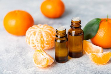 Tahta bir masada mandalina yağı. Bir şişe turunçgil yağı ve dilimlenmiş meyve. Mandalina kokulu mandalina yağı. Spa tedavileri için kozmetik yağı. Aromaterapi konsepti. Doğal kozmetikler. Geleneksel tıp. Metin için boşluk.