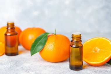 Tahta bir masada mandalina yağı. Bir şişe turunçgil yağı ve dilimlenmiş meyve. Mandalina kokulu mandalina yağı. Spa tedavileri için kozmetik yağı. Aromaterapi konsepti. Doğal kozmetikler. Geleneksel tıp. Metin için boşluk.