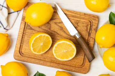 Tahta bir masada limon. Bir dilim taze limon. Turunçgil yapraklı taze limon. Limon suyu. Yemek ve içecek malzemeleri hazırlanıyor. Sağlıklı beslenme. Metin için C vitamini alanı.