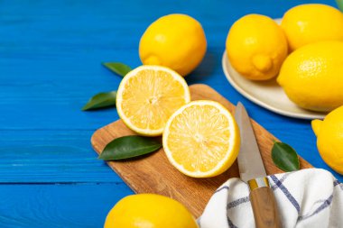 Tahta bir masada limon. Bir dilim taze limon. Turunçgil yapraklı taze limon. Limon suyu. Yemek ve içecek malzemeleri hazırlanıyor. Sağlıklı beslenme. Metin için C vitamini alanı.