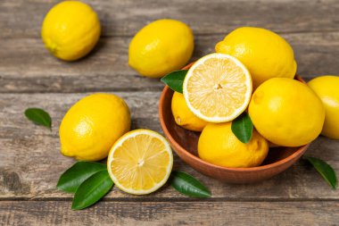 Tahta bir masada limon. Bir dilim taze limon. Turunçgil yapraklı taze limon. Limon suyu. Yemek ve içecek malzemeleri hazırlanıyor. Sağlıklı beslenme. Metin için C vitamini alanı.