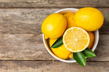 Tahta bir masada limon. Bir dilim taze limon. Turunçgil yapraklı taze limon. Limon suyu. Yemek ve içecek malzemeleri hazırlanıyor. Sağlıklı beslenme. Metin için C vitamini alanı.