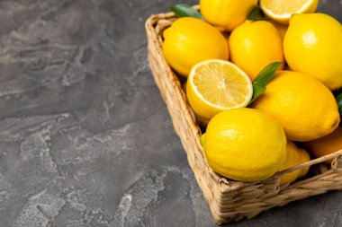 Tahta bir masada limon. Bir dilim taze limon. Turunçgil yapraklı taze limon. Limon suyu. Yemek ve içecek malzemeleri hazırlanıyor. Sağlıklı beslenme. Metin için C vitamini alanı.