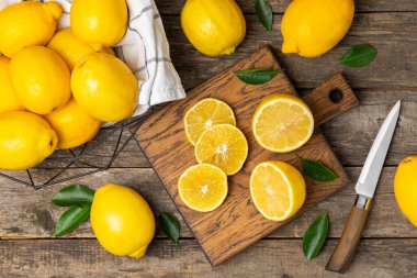 Tahta bir masada limon. Bir dilim taze limon. Turunçgil yapraklı taze limon. Limon suyu. Yemek ve içecek malzemeleri hazırlanıyor. Sağlıklı beslenme. Metin için C vitamini alanı.