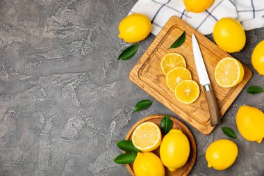 Tahta bir masada limon. Bir dilim taze limon. Turunçgil yapraklı taze limon. Limon suyu. Yemek ve içecek malzemeleri hazırlanıyor. Sağlıklı beslenme. Metin için C vitamini alanı.