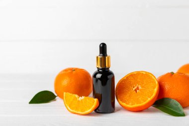 Tahta bir masada mandalina yağı. Bir şişe turunçgil yağı ve dilimlenmiş meyve. Mandalina kokulu mandalina yağı. Spa tedavileri için kozmetik yağı. Aromaterapi konsepti. Doğal kozmetikler. Geleneksel tıp. Metin için boşluk.