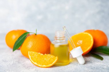 Tahta bir masada mandalina yağı. Bir şişe turunçgil yağı ve dilimlenmiş meyve. Mandalina kokulu mandalina yağı. Spa tedavileri için kozmetik yağı. Aromaterapi konsepti. Doğal kozmetikler. Geleneksel tıp. Metin için boşluk.
