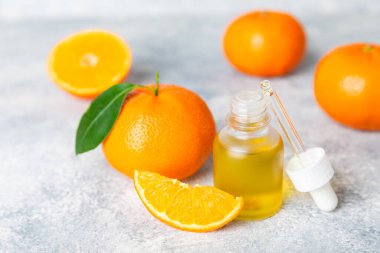 Tahta bir masada mandalina yağı. Bir şişe turunçgil yağı ve dilimlenmiş meyve. Mandalina kokulu mandalina yağı. Spa tedavileri için kozmetik yağı. Aromaterapi konsepti. Doğal kozmetikler. Geleneksel tıp. Metin için boşluk.