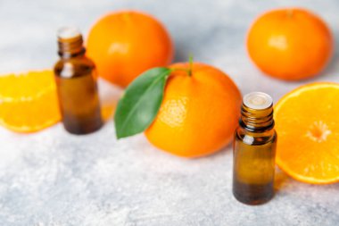 Tahta bir masada mandalina yağı. Bir şişe turunçgil yağı ve dilimlenmiş meyve. Mandalina kokulu mandalina yağı. Spa tedavileri için kozmetik yağı. Aromaterapi konsepti. Doğal kozmetikler. Geleneksel tıp. Metin için boşluk.