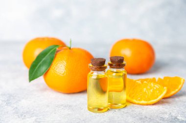 Tahta bir masada mandalina yağı. Bir şişe turunçgil yağı ve dilimlenmiş meyve. Mandalina kokulu mandalina yağı. Spa tedavileri için kozmetik yağı. Aromaterapi konsepti. Doğal kozmetikler. Geleneksel tıp. Metin için boşluk.