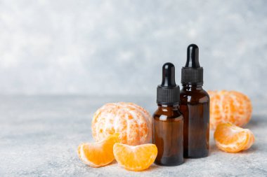 Tahta bir masada mandalina yağı. Bir şişe turunçgil yağı ve dilimlenmiş meyve. Mandalina kokulu mandalina yağı. Spa tedavileri için kozmetik yağı. Aromaterapi konsepti. Doğal kozmetikler. Geleneksel tıp. Metin için boşluk.