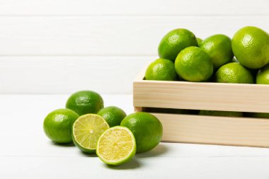 Tahta bir masada taze kireç. Masadaki bütün limon ve dilimler bir kasede. Citrus. C vitamini diyeti. Tropik meyveler. Yaz ferahlatıcı limonata ya da mojito konsepti. Mesaj için yer var. Boşluğu kopyala.