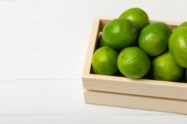 Tahta bir masada taze kireç. Masadaki bütün limon ve dilimler bir kasede. Citrus. C vitamini diyeti. Tropik meyveler. Yaz ferahlatıcı limonata ya da mojito konsepti. Mesaj için yer var. Boşluğu kopyala.
