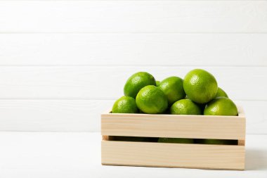 Tahta bir masada taze kireç. Masadaki bütün limon ve dilimler bir kasede. Citrus. C vitamini diyeti. Tropik meyveler. Yaz ferahlatıcı limonata ya da mojito konsepti. Mesaj için yer var. Boşluğu kopyala.