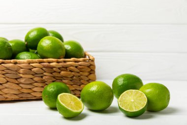 Tahta bir masada taze kireç. Masadaki bütün limon ve dilimler bir kasede. Citrus. C vitamini diyeti. Tropik meyveler. Yaz ferahlatıcı limonata ya da mojito konsepti. Mesaj için yer var. Boşluğu kopyala.