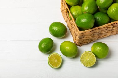Tahta bir masada taze kireç. Masadaki bütün limon ve dilimler bir kasede. Citrus. C vitamini diyeti. Tropik meyveler. Yaz ferahlatıcı limonata ya da mojito konsepti. Mesaj için yer var. Boşluğu kopyala.