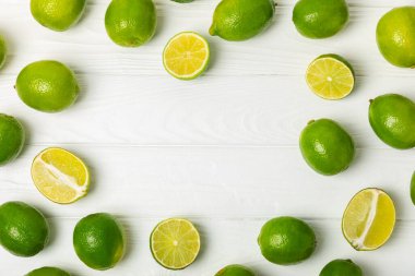 Tahta bir masada taze kireç. Masadaki bütün limon ve dilimler bir kasede. Citrus. C vitamini diyeti. Tropik meyveler. Yaz ferahlatıcı limonata ya da mojito konsepti. Mesaj için yer var. Boşluğu kopyala.
