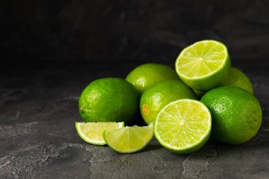 Tahta bir masada taze kireç. Masadaki bütün limon ve dilimler bir kasede. Citrus. C vitamini diyeti. Tropik meyveler. Yaz ferahlatıcı limonata ya da mojito konsepti. Mesaj için yer var. Boşluğu kopyala.