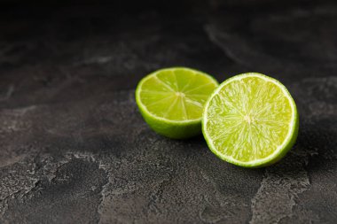 Tahta bir masada taze kireç. Masadaki bütün limon ve dilimler bir kasede. Citrus. C vitamini diyeti. Tropik meyveler. Yaz ferahlatıcı limonata ya da mojito konsepti. Mesaj için yer var. Boşluğu kopyala.