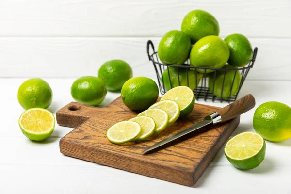 Tahta bir masada taze kireç. Masadaki bütün limon ve dilimler bir kasede. Citrus. C vitamini diyeti. Tropik meyveler. Yaz ferahlatıcı limonata ya da mojito konsepti. Mesaj için yer var. Boşluğu kopyala.