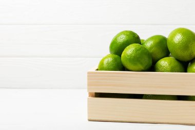 Tahta bir masada taze kireç. Masadaki bütün limon ve dilimler bir kasede. Citrus. C vitamini diyeti. Tropik meyveler. Yaz ferahlatıcı limonata ya da mojito konsepti. Mesaj için yer var. Boşluğu kopyala.