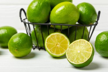 Tahta bir masada taze kireç. Masadaki bütün limon ve dilimler bir kasede. Citrus. C vitamini diyeti. Tropik meyveler. Yaz ferahlatıcı limonata ya da mojito konsepti. Mesaj için yer var. Boşluğu kopyala.